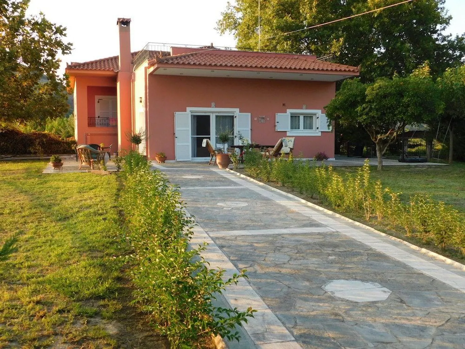 Πλακόστρωτος διάδρομος μέσα από το γρασίδι ως την είσοδο της βίλας